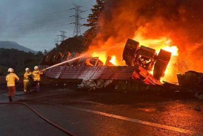 Anggota bomba melakukan.kerja-kerja pemadaman treler yang terbakar ketika proses dialihkan. Foto JBPM Pahang