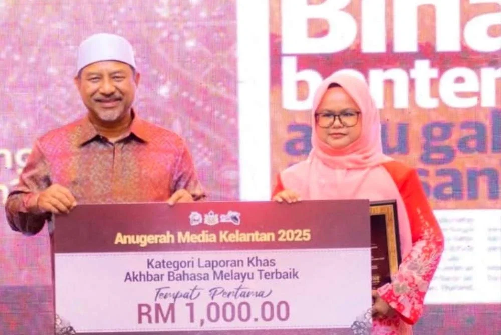 Hazelen Liana Kamarudin merangkul tempat pertama menerusi laporan khas bertajuk ‘Bina Benteng atau Gali Terusan?’ sekali gus membawa pulang wang tunai RM1,000 berserta plak kemenangan. Foto: UPKN