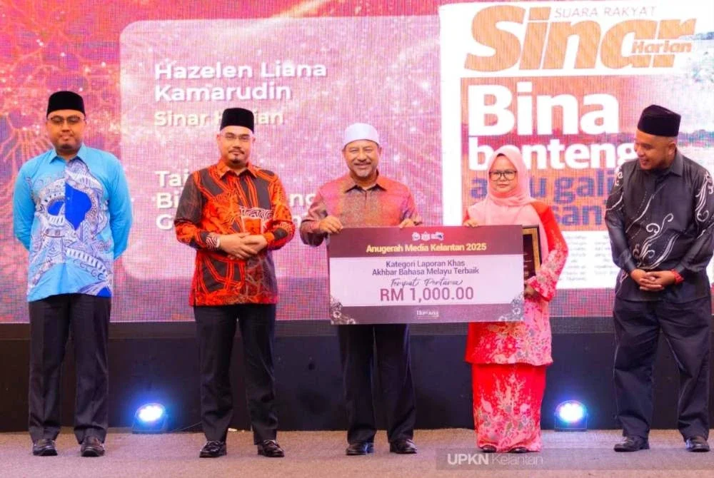 Hazelen Liana (dua dari kanan) menerima replika hadiah kemenangan disampaikan Mohd Nassuruddin (tengah) pada Malam Anugerah Media Kelantan, sempena Hawana Peringkat Negeri Kelantan di Kota Bharu pada Sabtu. Foto: UPKN