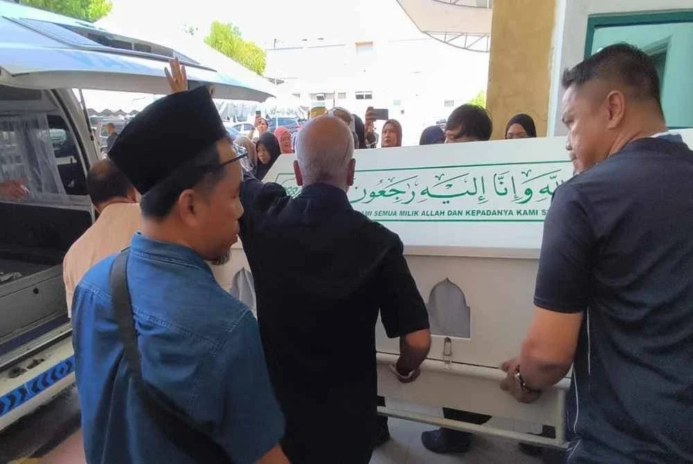 Jenazah salah sorang daripada mangsa di bawa masuk ke dalam van untuk disolatkan