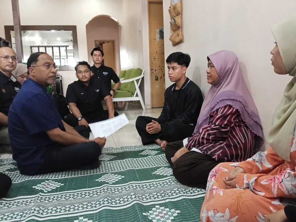 Zambry (kiri) menyantuni penerima Biasiswa Anak eKasih PTPTN (BAeK PTPTN) di Taman Putri, Kulai.