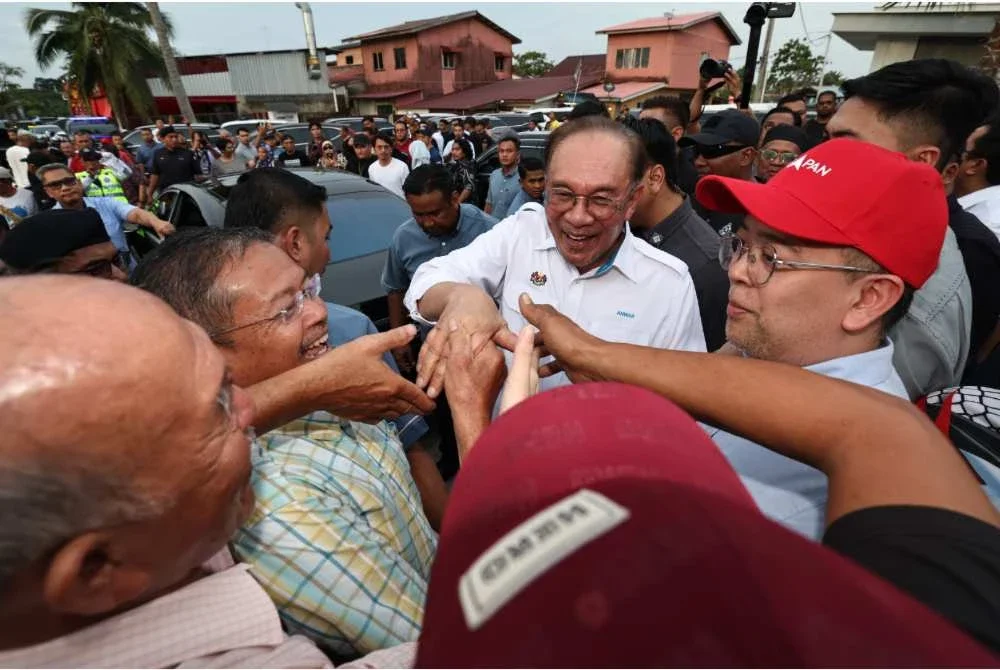 Anwar (tengah) berinteraksi bersama penduduk setempat selepas menghadiri Majlis Hi-Tea Bersama Komuniti Nelayan, Petani, Usahawan IKS, Belia Tempatan, Warga Pendidik dan Masyarakat Setempat di 9 Medan Selera Pantai Leka. -Foto Bernama