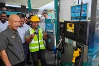 Armizan (kiri) melihat pemandu lori menggunakan kad Fleet di salah sebuah stesen minyak di Kapayan, Kota Kinabalu.