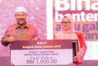 Hazelen Liana Kamarudin merangkul tempat pertama menerusi laporan khas bertajuk ‘Bina Benteng atau Gali Terusan?’ sekali gus membawa pulang wang tunai RM1,000 berserta plak kemenangan. Foto: UPKN