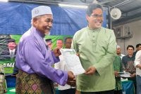 Tuan Ibrahim (kiri) menyerahkan borang keahlian Pas kepada Mohamad Rafie.