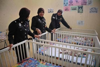 Dari kiri, Timbalan Penguasa Penjara, Najah Mohd Noor, Farah dan Siti Noor Aznee melihat anak kepada warga asing yang menjalani hukuman di Penjara Pokok Sena. FOTO: PENJARA POKOK SENA
