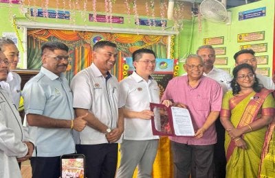 Kah Woh (tengah) nenyerahkan surat kelulusan pembinaan bangunan baharu SJKT Rajaji kepada Lembaga Pengelola Sekolah SJKT Rajaji pada Isnin.
