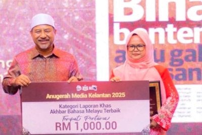 Hazelen Liana Kamarudin merangkul tempat pertama menerusi laporan khas bertajuk ‘Bina Benteng atau Gali Terusan?’ sekali gus membawa pulang wang tunai RM1,000 berserta plak kemenangan. Foto: UPKN