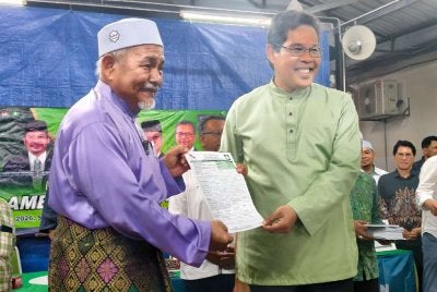 Tuan Ibrahim (kiri) menyerahkan borang keahlian Pas kepada Mohamad Rafie.