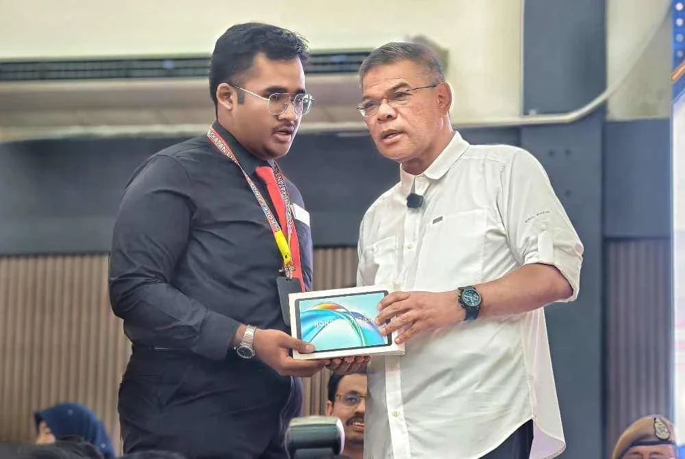 Saifuddin Nasution menyerahkan hadiah kepada pelajar yang berjaya menjawab soalan ketika Program Citra Negara MDN Sekolah Selamat di Kolej Tingkatan Enam Tuanku Muhriz