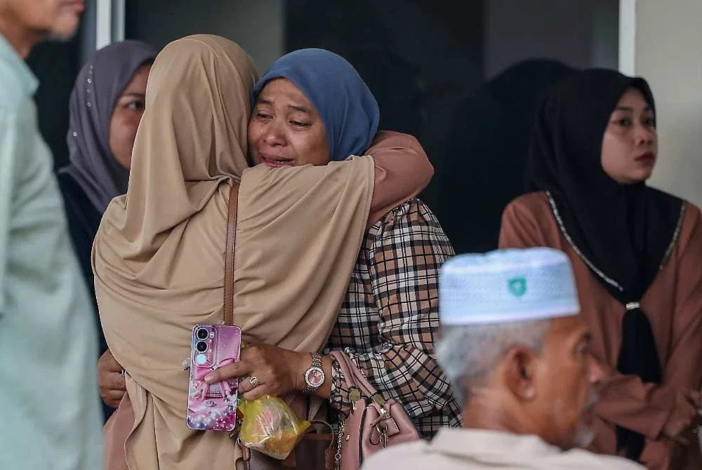Siti Fairuz Mohamed Yusof, 38, sebak ketika menunggu proses bedah siasat suaminya, Allahyarham Koperal Norazmi ketika ditemui di Jabatan Forensik HSB pada Selasa. Foto: Bernama