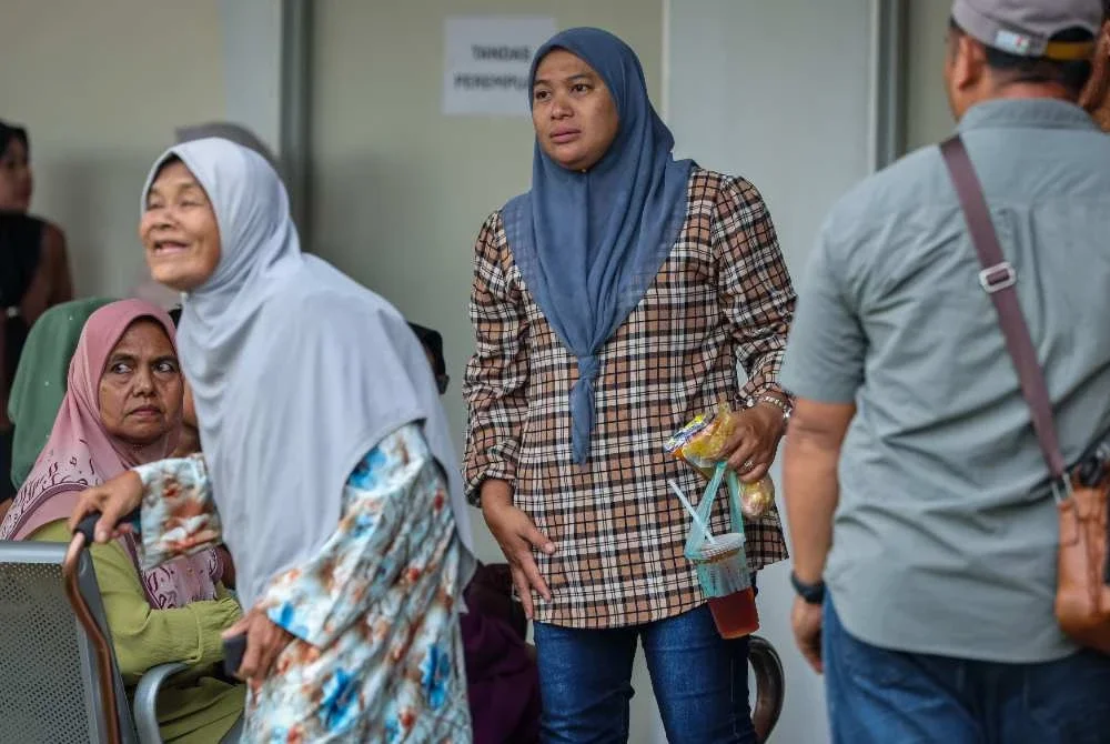Siti Fairuz Mohamed Yusof, 38 bersama ibu mertuanya, Fatimah Ismail, 78 (kiri) menunggu proses bedah siasat Allahyarham Koperal Norazmi. Foto: Bernama