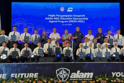 Asyraf (tengah) bergambar bersama kenamaan serta penerima biasiswa MESH-MISC pada Isnin.