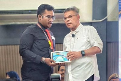 Saifuddin Nasution menyerahkan hadiah kepada pelajar yang berjaya menjawab soalan ketika Program Citra Negara MDN Sekolah Selamat di Kolej Tingkatan Enam Tuanku Muhriz 