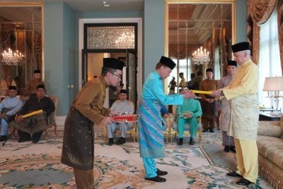 Sultan Nazrin (kanan) menyerahkan bayaran zakat berkenaan kepada Mohd Annuar dalam majlis yang berlangsung di Istana Kinta pada Selasa.