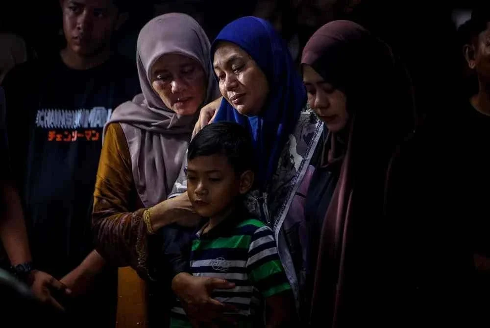 Siti Fairuz Mohamed Yusof, 38, tidak menahan kesedihan ketika jenazah suaminya Allahyarham Koperal Norazmi Abu Bakar, 40, dikebumikan di Tanah Perkuburan Islam Masjid Al-Busyra kira-kira 4.30 pagi tadi. Foto Bernama. 