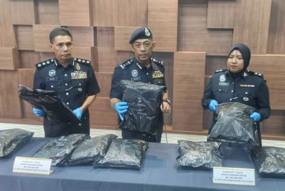 Baderulhisham (tengah) menunjukkan bungkusan mengandungi dipercayai bunga ganja yang dirampas dalam pemeriksaan di Kompleks Imigresen, Kastam, Kuarantin dan Keselamatan (ICQS) Bukit Kayu Hitam pada Isnin.