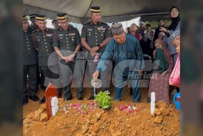 Sungip menyiram air mawar di pusara anaknya di Tanah Perkuburan Islam Taman Sri Lambak Kluang pada Rabu.