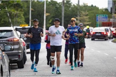 Choo Seong (tengah) memulakan larian sejauh 290 KM dari Taiping ke Parlimen, Kuala Lumpur di Pekan Ipoh pada Rabu. - FOTO: Bernama