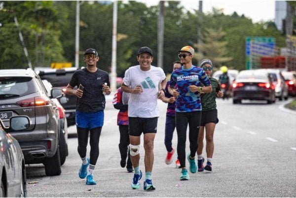 Choo Seong (tengah) memulakan larian sejauh 290 KM dari Taiping ke Parlimen, Kuala Lumpur di Pekan Ipoh pada Rabu. - FOTO: Bernama
