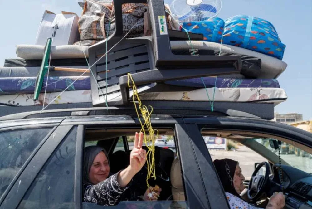 Seorang wanita yang mengangkat isyarat tangan dari sebuah kereta ketika pulang bersama ahli keluarganya ke kediaman mereka di selatan Lubnan melalui lebuh raya di Sidon. Foto: Reuters.