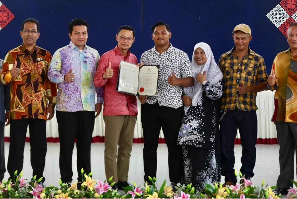 Timbalan Pengarah Pendidikan Sektor Pembelajaran Jabatan Pendidikan Negeri Terengganu (JPNT), Wan Zuraidi Che Wan Zaid (tiga dari kiri) menyampaikan sijil penghargaan kepada pelajar cemerlang STPM di SMK Bukit Sawa di Marang selepas majlis pengumuman keputusan STPM 2025 Terengganu pada Khamis.