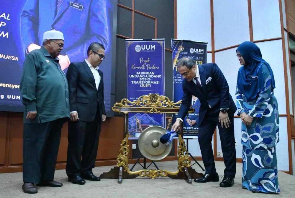 Dusuki Mokhtar (dua dari kanan) memalu gong bagi melancarkan Projek Komuniti Perdana Jaringan Undang-Undang Sosio-Transformasi (JUST) Universiti Utara Malaysia