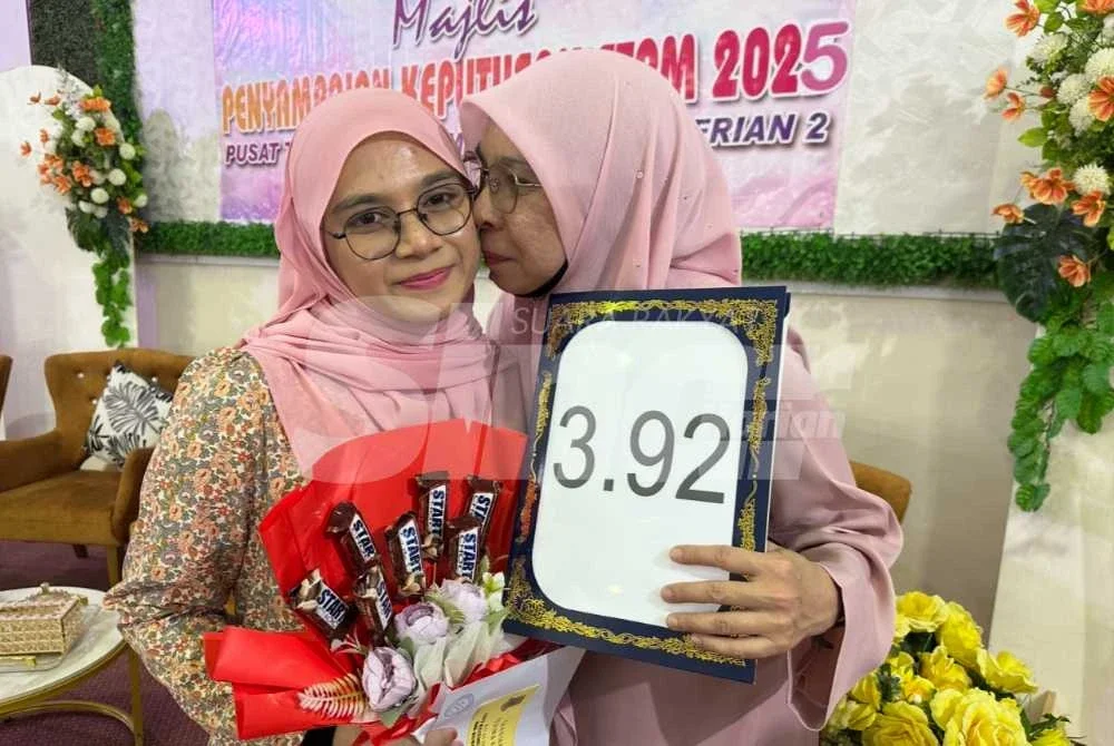 Bariyyatul Busyra (kiri) dicium ibunya tanda kegembiraan selepas memperoleh keputusan STPM.