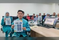 Ahmad Faidzul (hadapan) menunjukkan info grafik prestasi keputusan STPM negeri Perak di JPN Perak pada Khamis.