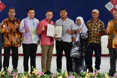 Timbalan Pengarah Pendidikan Sektor Pembelajaran Jabatan Pendidikan Negeri Terengganu (JPNT), Wan Zuraidi Che Wan Zaid (tiga dari kiri) menyampaikan sijil penghargaan kepada pelajar cemerlang STPM di SMK Bukit Sawa di Marang selepas majlis pengumuman keputusan STPM 2025 Terengganu pada Khamis.