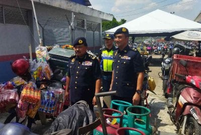 Ahmad Kamarunzaman (kiri) menunjukkan kenderaan yang disita dalam Ops Pewa pada Khamis.