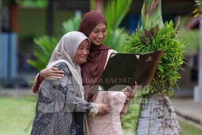Fatimah (kiri) memeluk Nurul Atikah selepas pengumuman keputusan Sijil Tinggi Persekolahan Malaysia (STPM) 2025 Terengganu di Sekolah Menengah Kebangsaan (SMK) Bukit Sawa, di Marang pada Khamis.