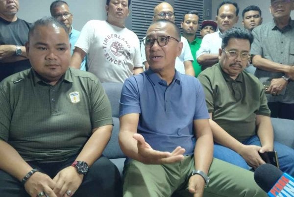 Zainol Fadzi (duduk, tengah) bersama penyelaras dan aktivis Reset Perak yang hadir ketika sidang media di Ipoh pada Khamis.
