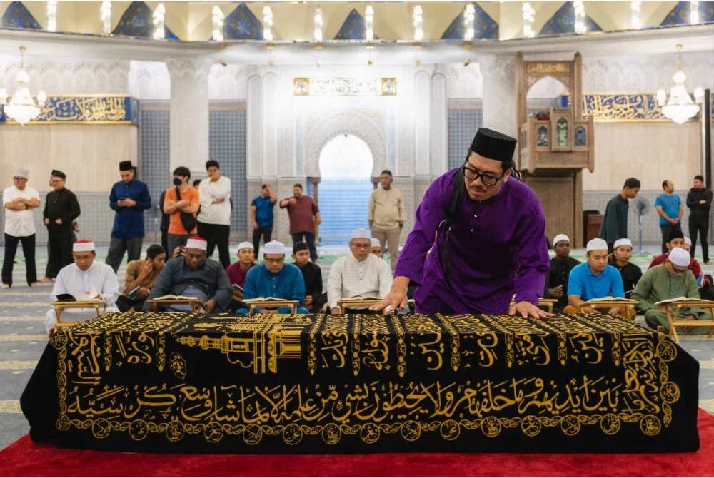 Faeroz Kamil membetulkan kain yang menutupi jenazah ayahnya Allahyarham Datuk Kamil Misuari, suami kepada Menteri Pembangunan Wanita, Keluarga dan Masyarakat Datuk Seri Nancy Shukri, selepas selesai solat jenazah di Masjid Negara semalam. - Foto: Bernama