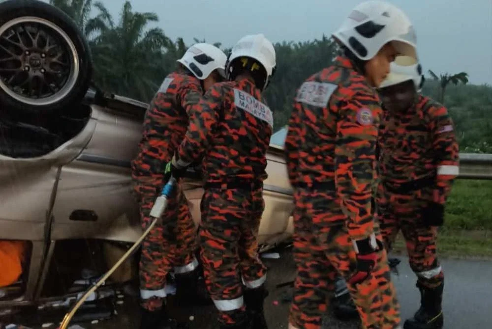 Anggota bomba mengeluarkan mangsa yang berada di dalam kenderaan yang terbalik dengan menggunakan peralatan khas menyelamat - Foto: JBPM Pahang