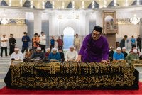 Faeroz Kamil membetulkan kain yang menutupi jenazah ayahnya Allahyarham Datuk Kamil Misuari, suami kepada Menteri Pembangunan Wanita, Keluarga dan Masyarakat Datuk Seri Nancy Shukri, selepas selesai solat jenazah di Masjid Negara semalam. - Foto: Bernama