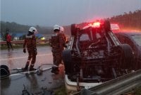 Anggota bomba dari BBP Jengka membantu mengeluarkan mangsa yang tersepit dalam kenderaan terbalik. - Foto JBPM Pahang