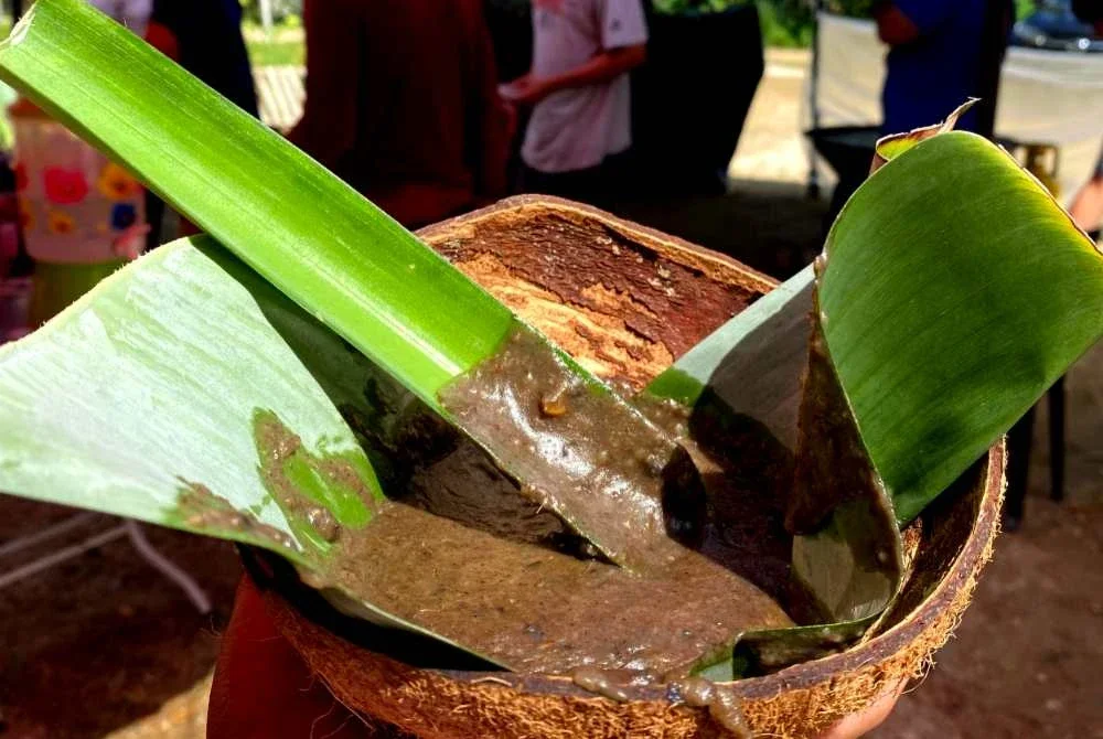 Makan bubur asyura menggunakan tempurung, daun nanas mengundang nostalgia lama.