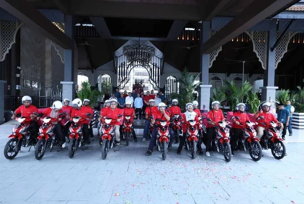 Mohamad (tengah) bersama 20 asnaf yang menerima motosikal dan kelengkapan penghantaran menerusi Program iTEKAD CIMB Islamic-MAINPP Entrepreneur.