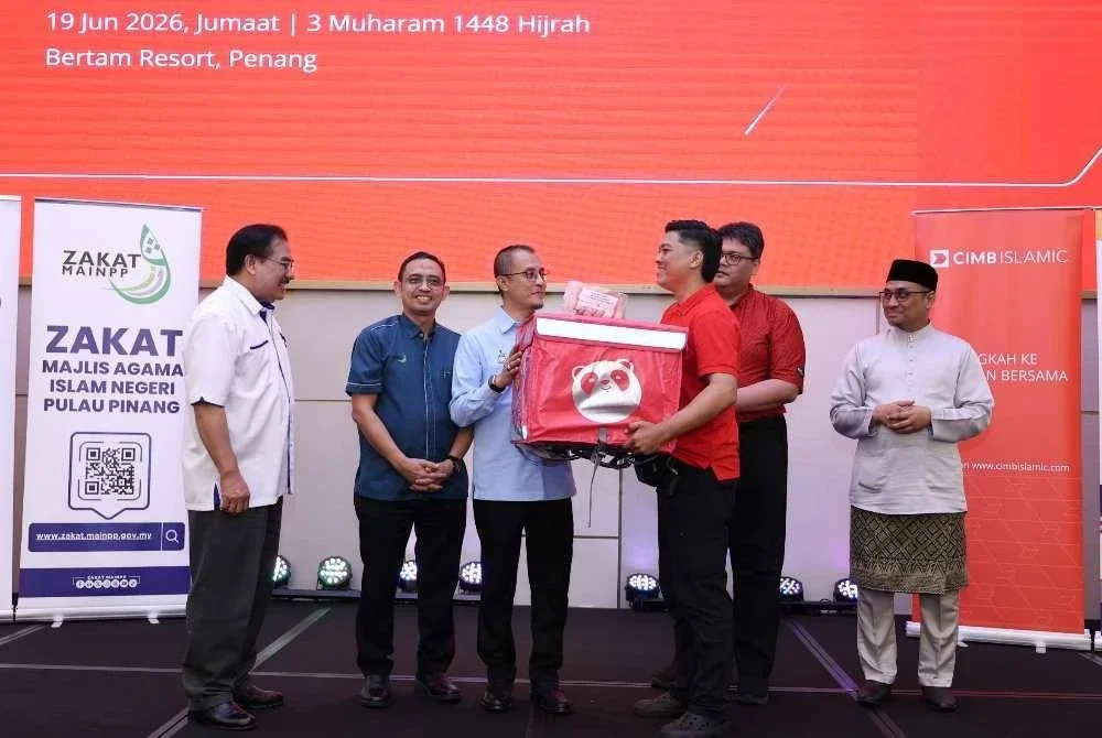 Mohamad (tiga dari kiri) memberi kelengkapan penghantaran kepada salah seorang asnaf yang layak menerusi Program iTEKAD CIMB Islamic-MAINPP Entrepreneur.