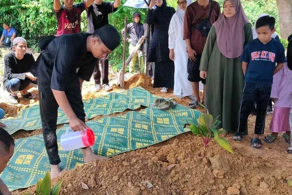 Mohamad Alif Iskandar menyiram pusara tunangnya yang dikebumikan di Tanah Perkuburan Islam Kampung Gau Baru di sini pada Sabtu.