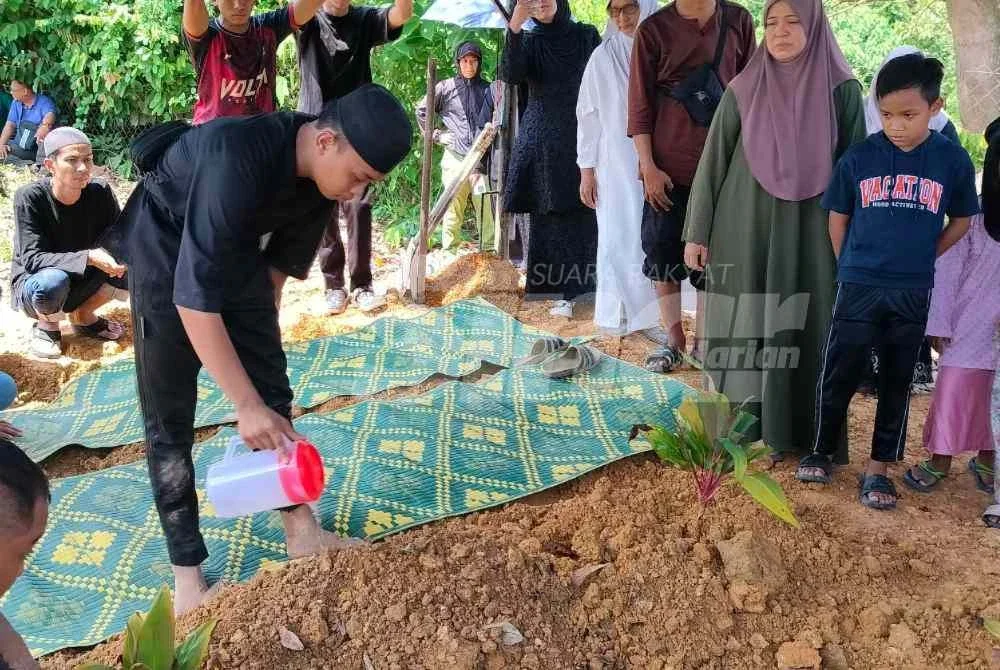 Mohamad Alif Iskandar menyiram pusara tunangnya yang dikebumikan di Tanah Perkuburan Islam Kampung Gau Baru di sini pada Sabtu.