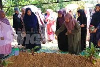 Nurul Alhana Othman, 48, menyiram pusara dua anak kesayangannya.