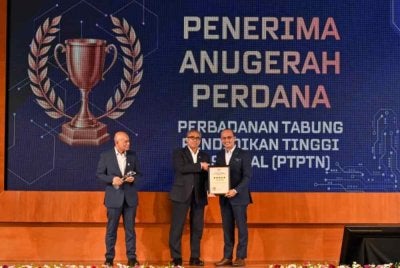Shamsul Azri (tengah) menyampaikan Anugerah Perdana Keselamatan Perlindungan Tahun 2025 kepada Ahmad Dasuki (kanan) pada Majlis Penyampaian Anugerah Khas Keselamatan Perlindungan dan Peluncuran Sistem Pengurusan Keselamatan Perlindungan (e-PS) serta Sistem e-Vetting 3.0 di Dewan Damar Sari 1 dan 2, Putrajaya.