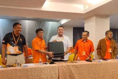 Khairol Najib (tiga dari kanan) menerima cenderahati daripada Asmuni selepas merasmikan Mesyuarat Tahunan Amanah Kawasan Tambun di sebuah hotel di sini pada Ahad.