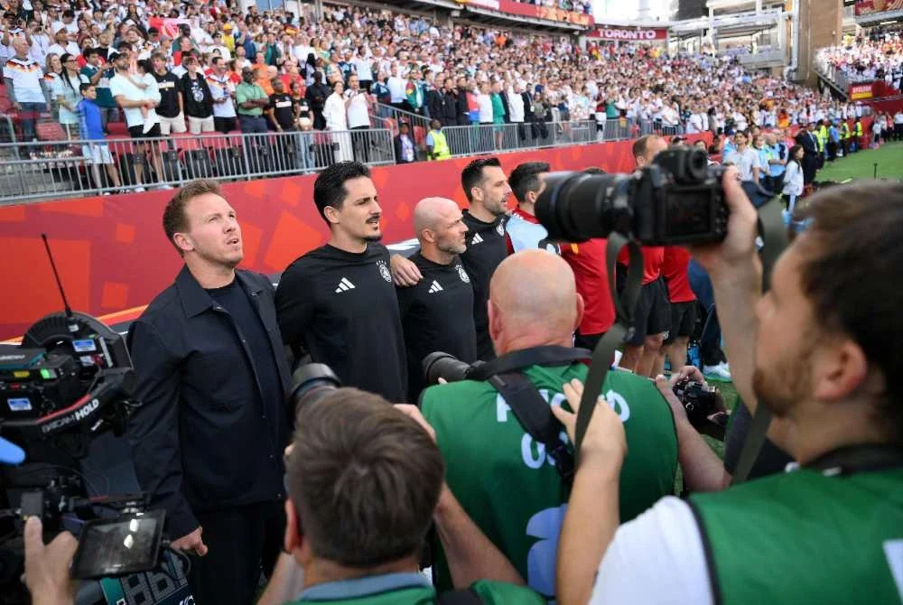 Pengendali Jerman, Julian Nagelsmann (kiri) menjadi jurulatih kedua yang tidak berpuas hati dengan kedudukan jurugambar semasa lagu kebangsaan sedang dinyanyikan.
