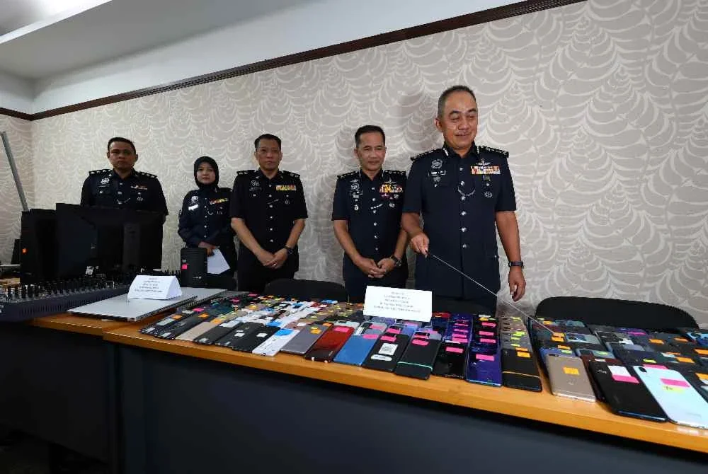 Mohd Alwi menunjukkan sebahagian barangan yang dirampas susulan kejayaan menumpaskan sindiket membekalkan telefon kepada sindiket penipuan ketika sidang akhar di IPK Perak pada Isnin.