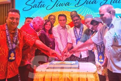 Andrew Raju (empat dari kiri) memotong kek bersama bapa tunggal yang diraikan sempena sambutan Hari Bapa. 
