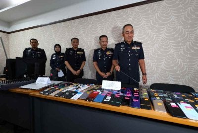 Mohd Alwi menunjukkan sebahagian barangan yang dirampas susulan kejayaan menumpaskan sindiket membekalkan telefon kepada sindiket penipuan ketika sidang akhar di IPK Perak pada Isnin.