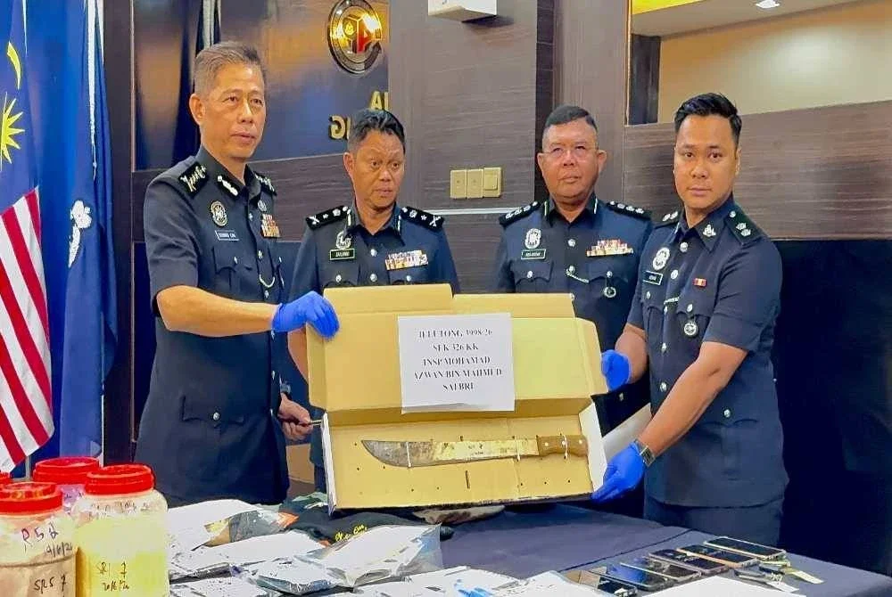 Dennis Lim (kiri) menunjukkan senjata yang digunakan dalam kejadian pada Ahad.